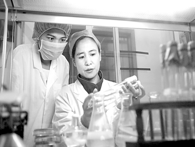 钟春燕(右一)带领公司技术人员在一起做实验。(资料照片)